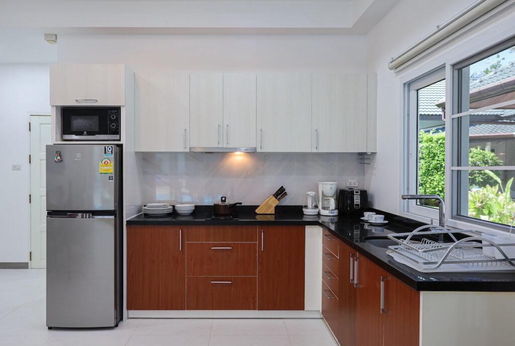 Fully equipped modern kitchen in Yanui Breeze apartment, featuring stainless steel appliances and ample counter space.